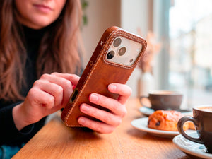 Ravenweave Ember leather iPhone case on café table