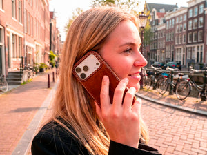 Ravenweave Ember oil-waxed leather iPhone case, outdoor lifestyle shot